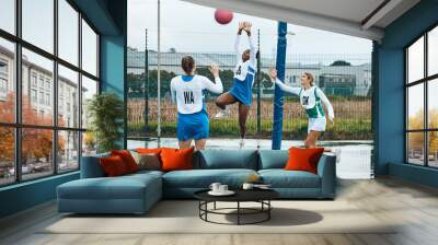 Netball, sports team and woman jump for ball, practice and playing game, court challenge or high school match. Fitness, teamwork and group workout, tournament and player action, exercise or training Wall mural