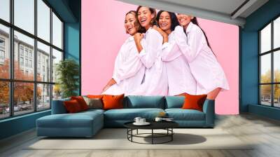 Women, friends and portrait in studio with natural beauty, diversity and white shirt with laugh. Pink background, bonding and young female group together with inclusion, happy smile and wellness Wall mural