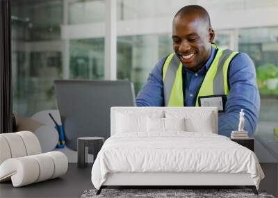 Laptop, architecture and a black man construction worker in an office for planning a building project. Computer, smile and a happy young engineer in the workplace for research as a contractor Wall mural