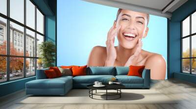 Portrait, beauty and hands of woman on face in studio for makeup, wellness or gentle cleaning on blue background. Face, skincare and girl skin model relax in luxury, facial or cosmetic while isolated Wall mural