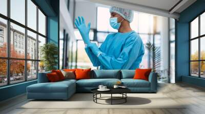 Surgeon, doctor with gloves and surgery with face mask and health, man in ppe for safety, operation and ready for procedure. Cardiovascular, clean scrubs and person in clinic with male physician Wall mural