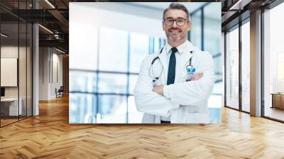 Doctor, man and happy with arms crossed in hospital for medical, career and happiness for portrait. Medic, smile and work in clinic for healthcare, wellness and health while working in Washington DC Wall mural