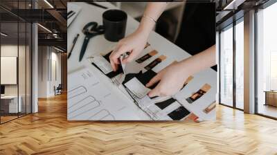 Young businesswoman and fashion designer reviewing her clothes design sketches Wall mural