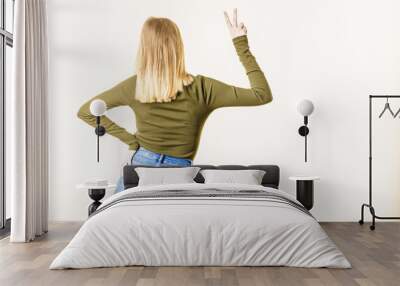 Back view of woman showing peace gesture Wall mural