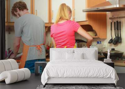 Couple woman and man cooking in kitchen. Wall mural