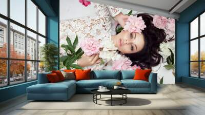 Beautiful woman with pink peony flowers, natural beauty, skin care. Perfect facial features. Girl posing on a light background Wall mural