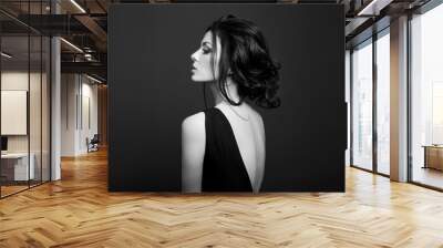 Classic Smokey makeup on woman face, beautiful big eyes. Fashion Perfect makeup, expressive eyes on girl face, smooth black eyebrows, licked brunette hair. Portrait of a woman on a dark background Wall mural