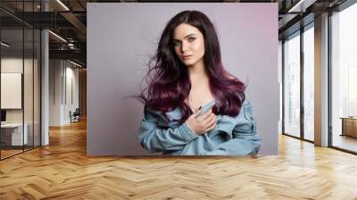 Portrait of a woman with bright colored flying hair, all shades of purple. Hair coloring, beautiful lips and makeup. Hair fluttering in the wind. Sexy girl with long hair styling Wall mural