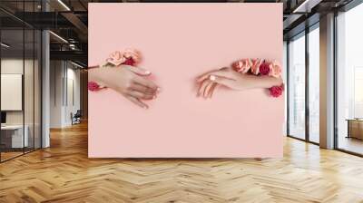 Set hands with artificial flowers sticking out of hole pink paper background. Hand in various poses, the pattern layout for your collage. Cosmetics hand skin care, moisturizing and wrinkle reduction Wall mural