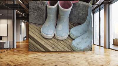 Pairs of muddy childrens wellington boots Wall mural