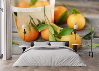 Fresh tasty tangerines with leaves on wooden table  Wall mural