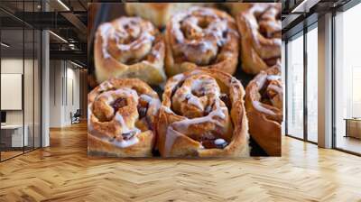 Plum cinnamon rolls fresh baked with sugar glaze on a baking sheet. Selective focus Wall mural