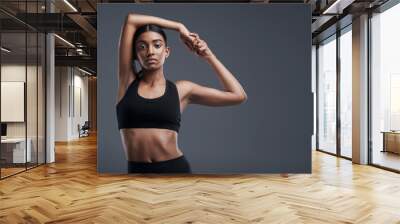 Portrait, mockup and stretch with a sporty woman in studio on a gray background for fitness or health. Exercise, workout and warm up with a young focused indian female athlete training her body Wall mural