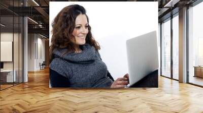 woman with laptop on white sheet in her bed at home Wall mural