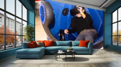 Child with virtual reality headset sitting in a chair booth Wall mural