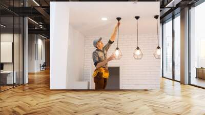 Electrician worker installation electric lamps light inside apartment. Construction decoration concept. Wall mural