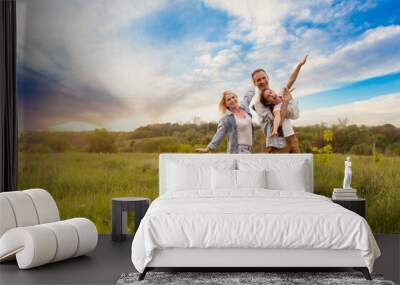 Happy family: mother father and child daughter on nature on sunset Wall mural