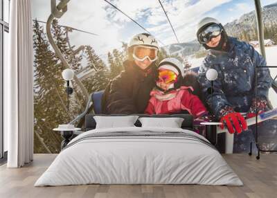 happy smiling family skiers on ski lift making selfie Wall mural