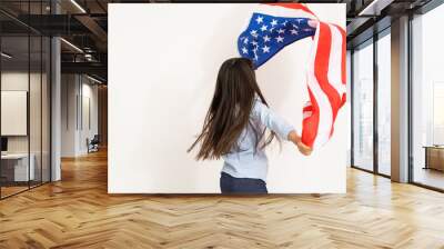 Image of a beautiful cheerful little girl with holding a big American flag Wall mural