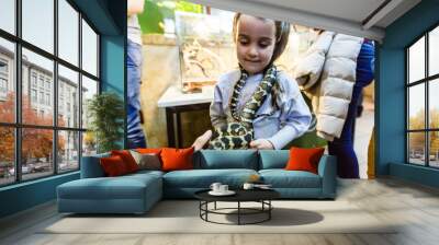 little girl with a snake. Snakes in a terrarium. Wall mural