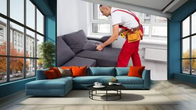 Man assembling sofa furniture at home Wall mural