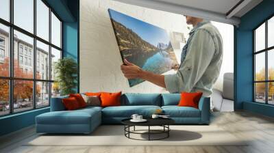 man holds photo canvas at home Wall mural