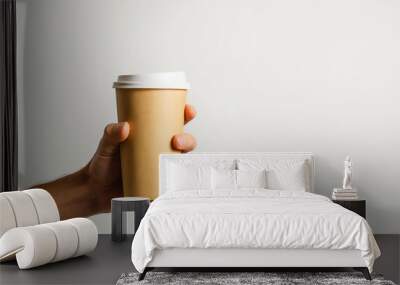 Mockup of male hand holding a Coffee paper cup isolated on light grey background Wall mural