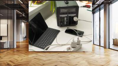 Portable power station charging gadgets on table in room. Wall mural