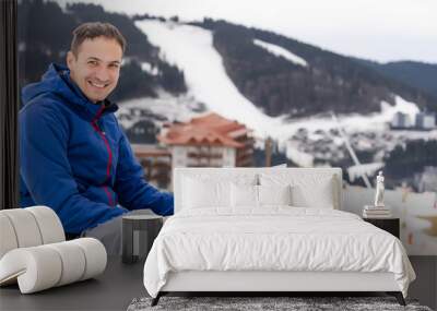 snowboarder typing on the laptop in the mountains winter Wall mural