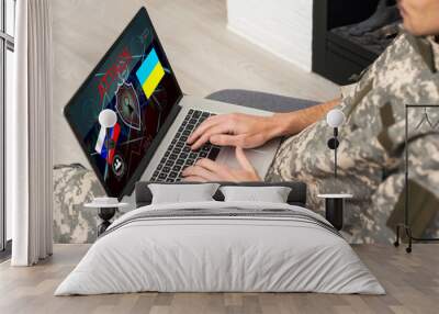 Surveillance and control of opposing information concept, Soldier in camouflage uniform working on laptop for Information Operation. Russia, Ukraine Wall mural