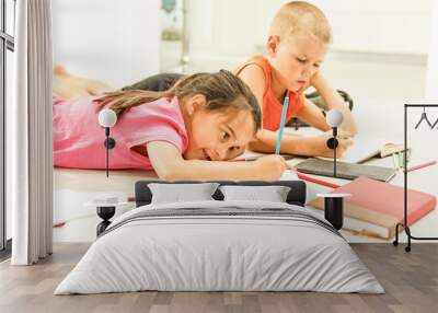 Two cute children draws on floor at home Wall mural