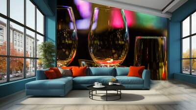 Two glasses of wine white and red standing on a table with candle in the sun light Wall mural