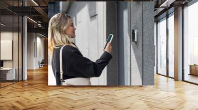 woman open the safety door with smart phone Wall mural