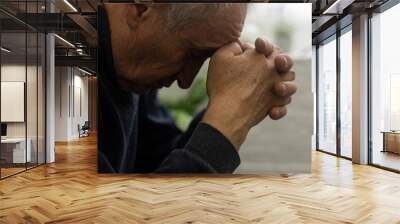 Worried religious senior man praying to god with his hands raised and touching as he looks beseechingly towards heaven for help and inspiration. Wall mural