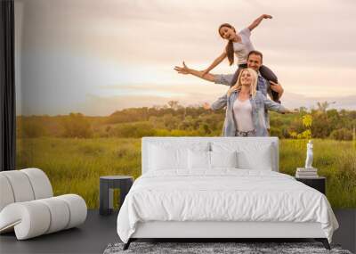 Young happy family in a field Wall mural