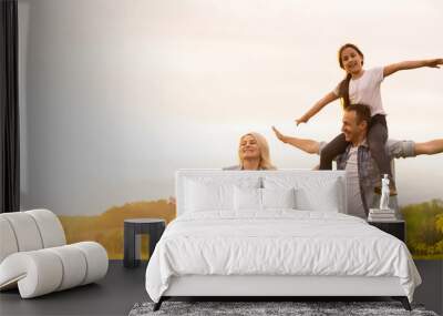 Young happy family in a field Wall mural