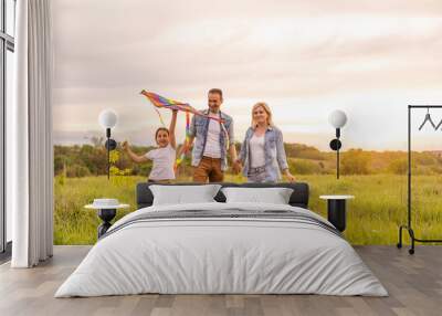 Young happy family in a field Wall mural