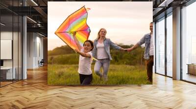 Young happy family in a field Wall mural