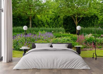 Flowerbeds and a green lawn in a summer garden Wall mural