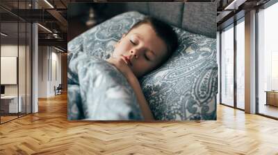 Cute boy sleeping in bed. Child 6-7 years old smiling, having a good dreams. Wall mural