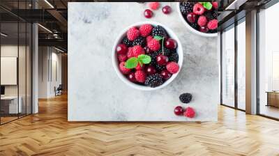 Summer fresh berries in white bowl on gray concrete table background. Top view with copy space. Vegetarian food - raspberry, blackberry and cherry Wall mural