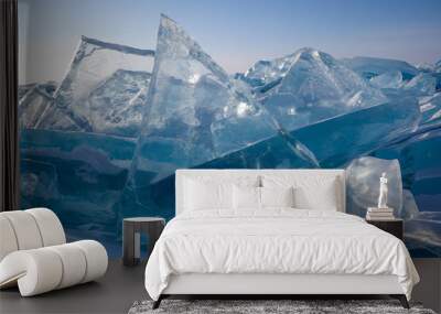 Scenic big blocks of broken transparent blue ice on clear sky background, beautiful winter landscape, closeup view Wall mural