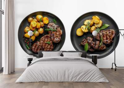 Set of black plate of grilled beef steaks and potatoes top view isolated on a transparent background Wall mural