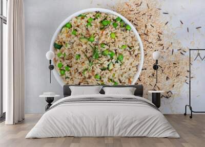 Wild and brown rice pilaf with green peas, onion and baby marrow on mottled grey with raw rice and copy space Wall mural