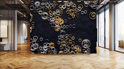 round metal links, accessories for jewelry making, scattered on a black background Wall mural