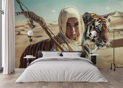 Muslim woman wearing a white hijab carrying a bow and arrow accompanied by a tiger in the middle of the desert Wall mural