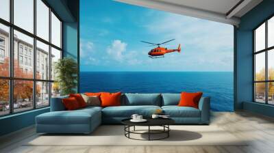 Helicopter hovering above the ocean, rescue diver being lowered into the water Wall mural