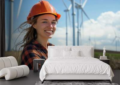 Cheerful woman wearing hard hat standing against turbines at wind farm on sunny day Wall mural