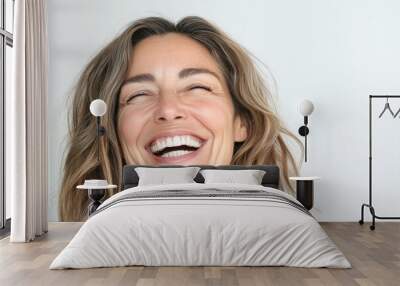 Close up portrait of a beautiful middle aged woman laughing against white background Wall mural