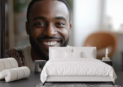 Happy african man looking at camera indoors at home   Focus on his face Wall mural